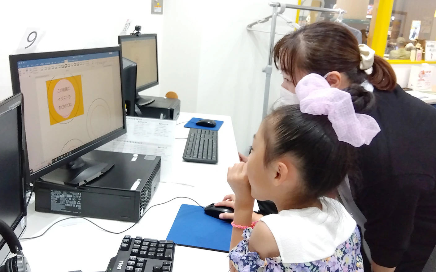 講師と生徒が一緒にパソコンの画面を見て学習している様子