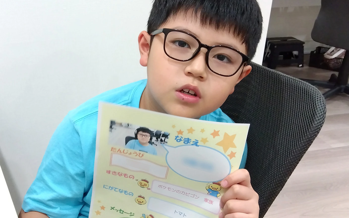 プログラミング教室で、自己紹介カードを手に持つ生徒の男の子8