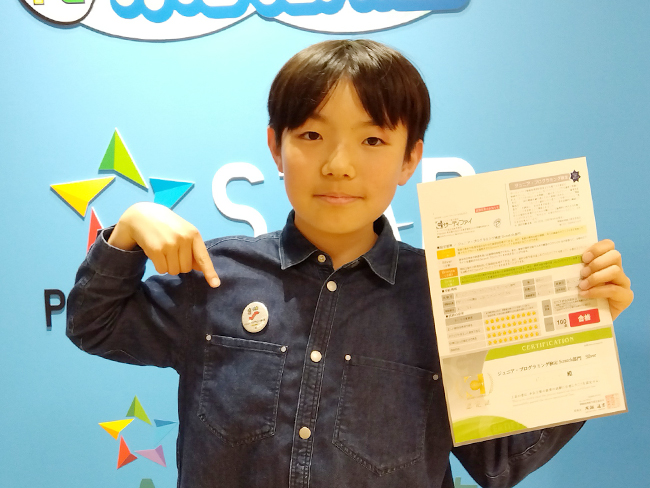 胸に輝く合格バッジ! ジュニアプログラミング検定100点の快挙!