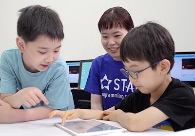 子どもと講師がタブレットを操作している
