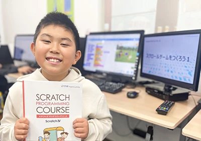 子どもがパソコンをバックにテキストを紹介している